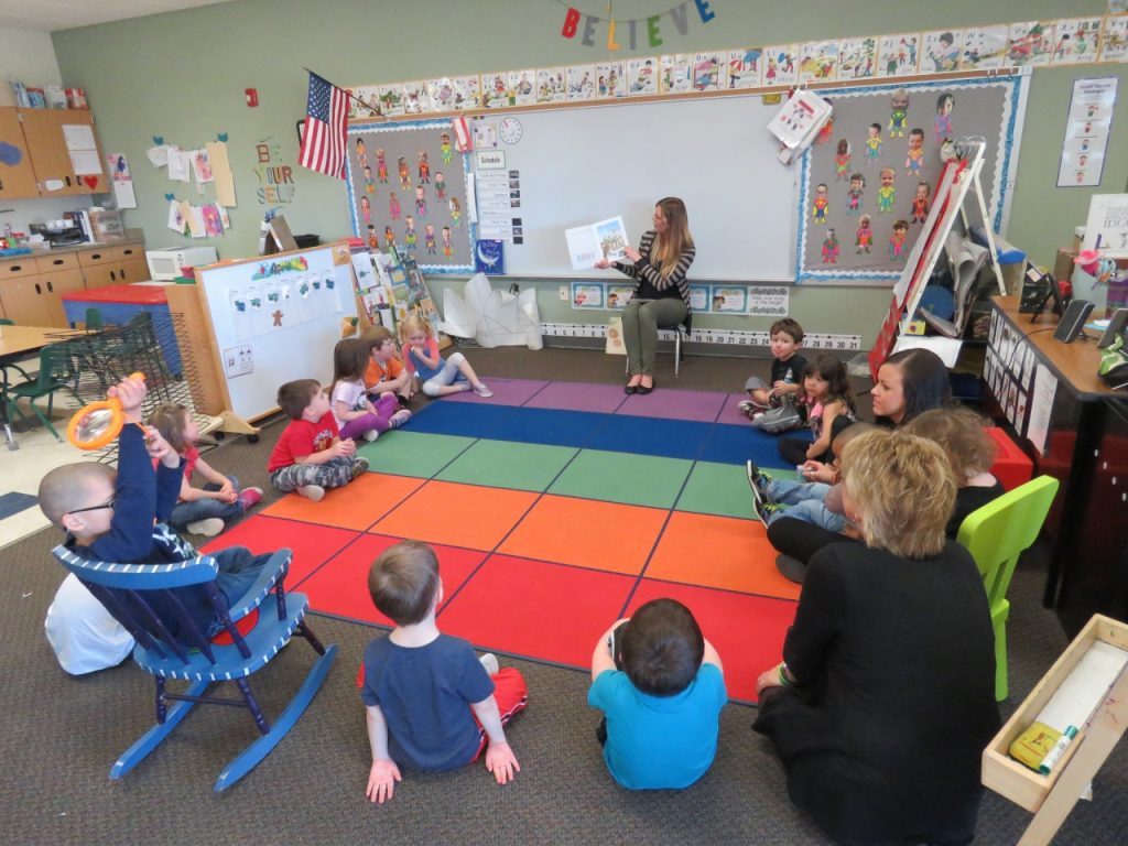 Students seated in classroom as Melissa Bray reads a book