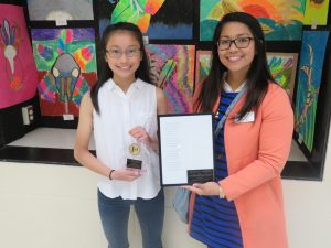 Oak Ridge Middle School’s Elizabeth Low accepts an award from Janet Abejo of the City of Cedar Rapids’ Civil Rights Commission for her award winning poem