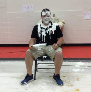 Mr. Phillips, Novak Elementary School Facilitator sitting in a chair after getting a pie to the face