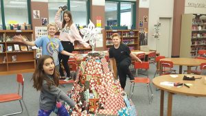 students standing around the Christmas tree made of wrapped books