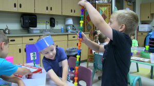 Two students create tower of blocks