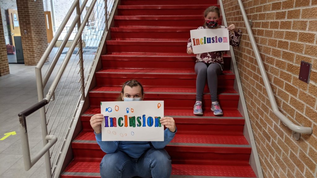Students holding Inclusion Signs